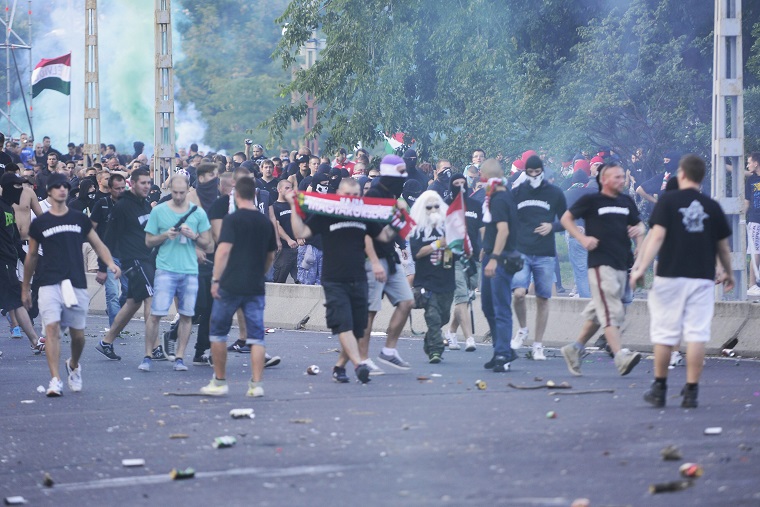 Szurkolók dobálják a rendőröket a magyar-román előtt. Fotó: MTI / Marjai János