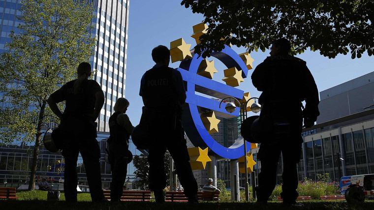 German riot police stand in front of the euro sign during a demonstration by Alternative fuer Deutschland outside ECB headquarters in Frankfurt