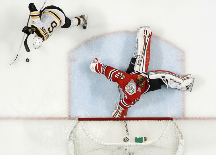 Blackhawks goalie Crawford makes a save on Bruins left wing Daugavins in overtime during Game 1 of their NHL Stanley Cup Finals hockey series in Chicago